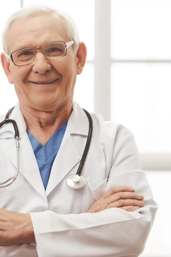 A doctor with his arms crossed and wearing glasses.